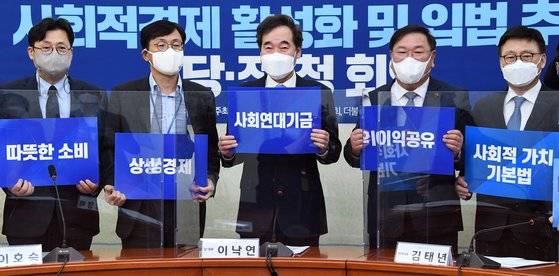 이낙연 더불어민주당 대표와 김태년 원내대표가 각각 '사회연대기금', '이익공유'라고 적힌 손 팻말을 들고 기념촬영을 하고 있다. 여권에서 코로나19 경제 위기 속에 상생 방안으로 마련된 사회연대기금과 이익공유제에 대해 기업에선 "팔 비틀기 정책 아니냐"는 우려가 나오고 있다. 오종택 기자