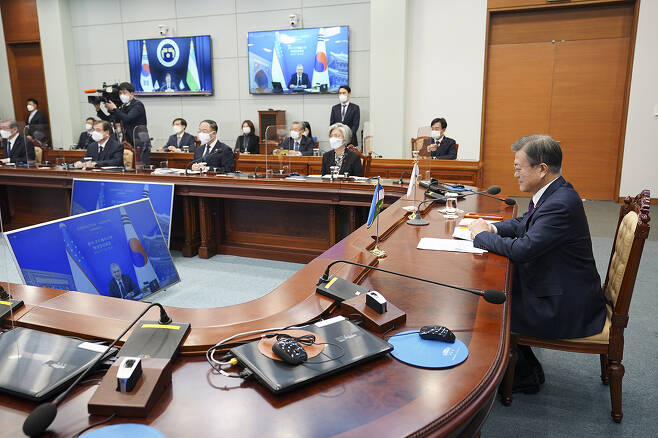 President Moon Jae-in holds a virtual summit with his Uzbek counterpart Shavkat Mirziyoyev (on the screen) at Cheong Wa Dae on Thursday.