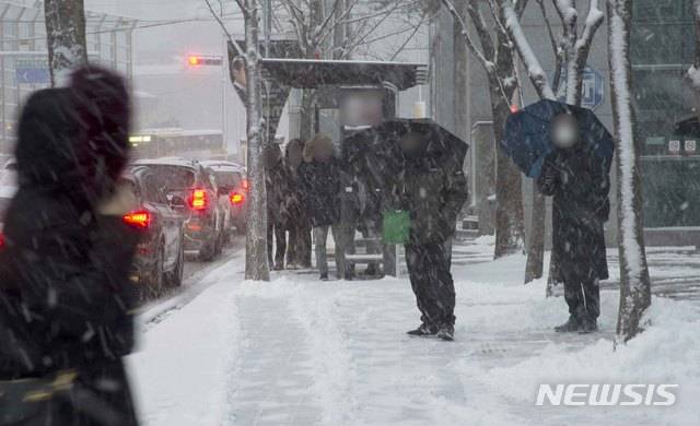 [광주=뉴시스] 김혜인 기자 = 광주와 전남 일부지역에 대설특보가 내려진 30일 오전 광주 남구 봉선동 한 길가에서 시민들이 출근길 버스를 기다리고 있다. 2020.12.30.hyein0342@newsis.com