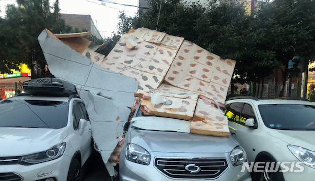[부산=뉴시스] 부산지역에 강풍주의보가 발효된 28일 오후 연제구의 한 빌라 9~10층 외벽에서 마감재가 강풍에 떨어져 지상에 주차된 차량 3대를 덮쳤다. (사진=부산경찰청 제공). 2020.01.28. photo@newsis.com