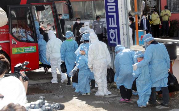 이송 버스 오르는 광주 TCS 국제학교 확진자 - 신종 코로나바이러스 감염증(코로나19) 집단 확진이 발생한 광주 광산구 운남동 광주 TCS 국제학교에서 확진자들이 치료 센터로 향하는 이송 버스에 오르고 있다. 이곳에서는 120여명이 합숙 생활을 하다가 113명이 코로나19에 확진됐다. 2021.1.27 연합뉴스