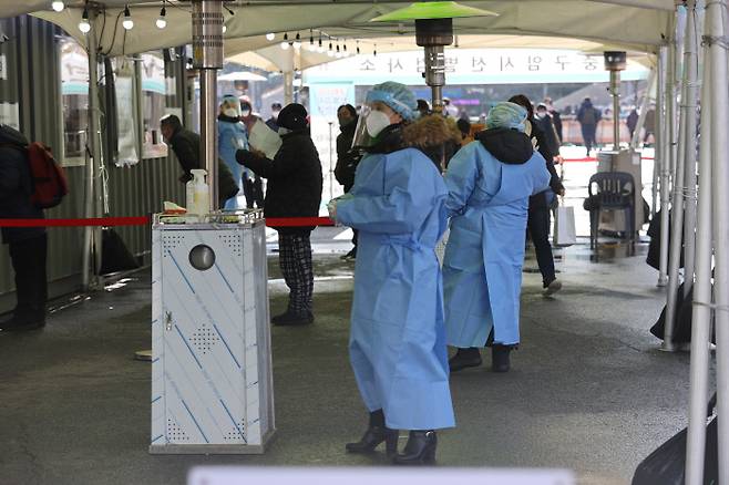 28일 서울역광장에 설치된 임시선별진료소에서 의료진이 시민 및 노숙인에게 검사 관련 안내를 하고 있다. 연합뉴스.