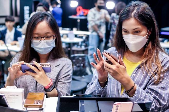 지난 14일 싱가포르 라이프스타일 공간 휴온(HUONE)에서 열린 '갤럭시 S21' 출시행사에 참석한 현지 기자들이 제품을 체험하고 있는 모습 [사진=삼성전자]