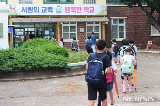 [제주=뉴시스] 양영전 기자 = 제주 한림초등학교 학생들이 건물 입구에서 열화상카메라를 통한 발열 체크를 거쳐 교실로 입장하기 위해 줄 서 있다. (사진=뉴시스DB) 0jeoni@newsis.com