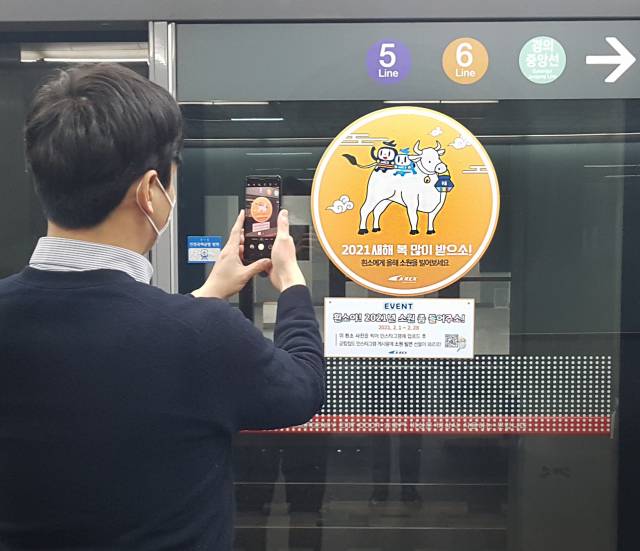 공항철도 공덕역에 부착된 이벤트 스티커를 촬영하며 이벤트에 참여하는 모습./사진제공=공항철도