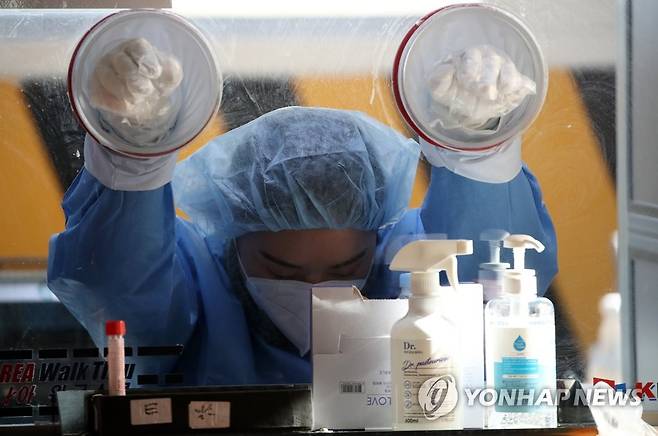 '두 손 든 채 막간휴식' (광주=연합뉴스) 조남수 기자 = 지난 20일 오후 광주 북구보건소 선별진료소 의료진이 바로 검체 채취를 할 수 있는 자세로 대기하고 있다. 2021.1.20