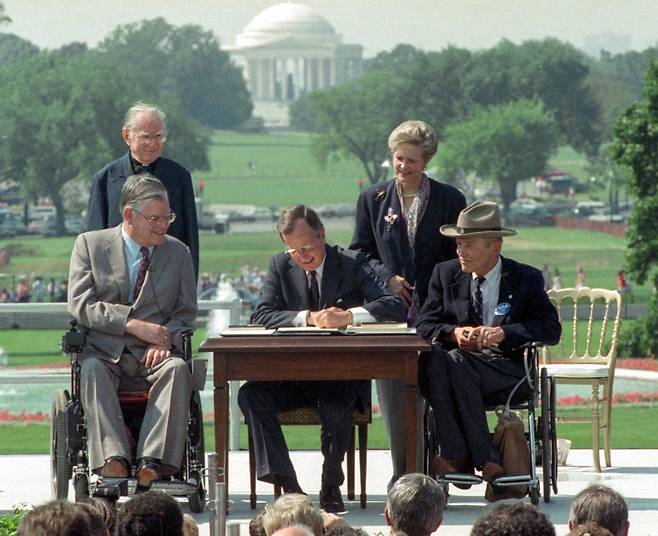 조지 H.W. 부시 대통령이 1990년 6월 장애인권익증진법에 서명하고 있다./AP, ShareAmerica