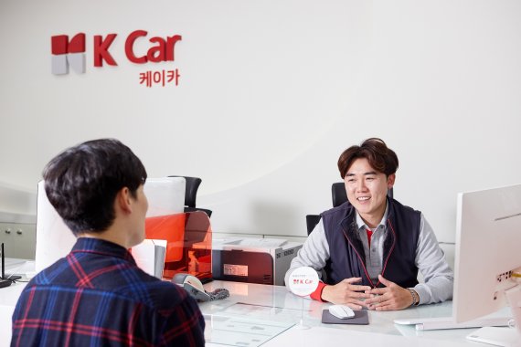 K Car 차량평가사가 고객과 차량 상담을 진행하고 있다