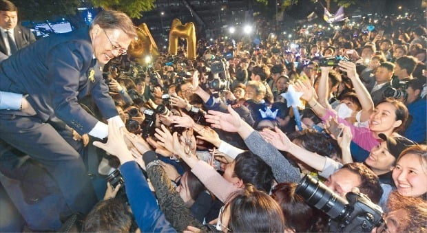 문재인 대통령이 2017년 대선에서 승리한 후 지지자들의 손을 잡아주고 있다. 신경훈 기자 khshin@hankyung.com