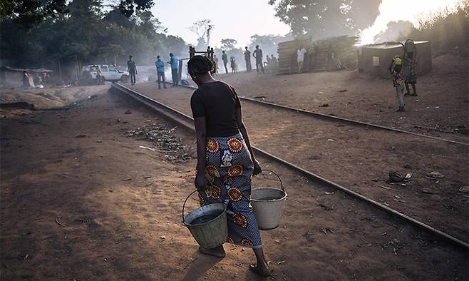 지난 21일 중앙 아프리카의 한 난민 여성이 난민촌으로 물을 실어 나르고 있다. AFP연합뉴스
