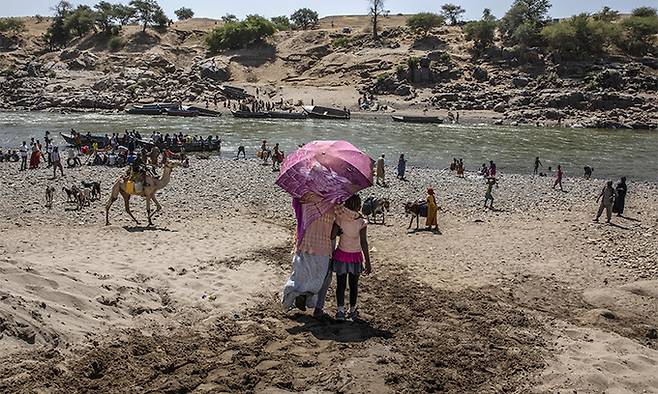 지난 21일 이디오피아 티그리 지역에서 충돌을 피한 난민들이 수단-이디오피아 국경의 테케즈 강변에 도착하고 있는 모습. AP연합뉴스