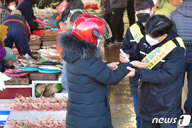 경북 포항시 수산진흥과 공무원들과 포항 수협관계자들이 31일 죽도시장 포항수협위판장에서설 재수용품 등을 구입하기 위해 나온 시민과 관광객, 상인들을 상대로 신종코로나바이러스 감염증(코로나19)발열체크를 하고 있다. 2021.1.31/뉴스1 © News1 최창호 기자