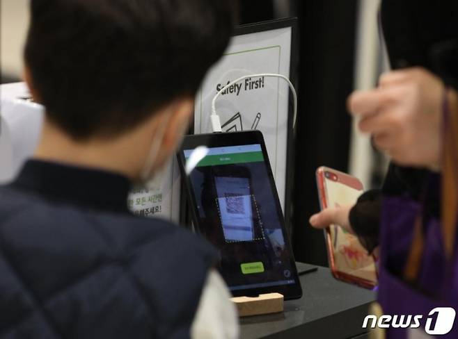 (서울=뉴스1) 신웅수 기자 = 새로운 사회적 거리두기 체계가 시행된 가운데 8일 오후 서울 영등포구 복합쇼핑몰인 타임스퀘어 내 식당에서 시민들이 전자출입명부(QR코드) 인증을 하고 있다.   새로운 사회적 거리두기 1단계에 따라 150㎡ 이상의 식당·카페 등 중점관리시설 9종에서 전자출입명부 작성이 의무화된다. 2020.11.8/뉴스1