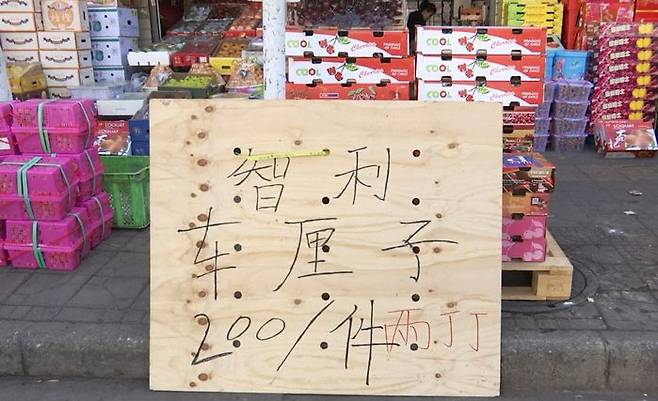 윈난성 쿤밍시의 한 과일 시장에 체리를 할인 판매한다는 팻말이 세워져 있다. (화면 출처=중국 CCTV)