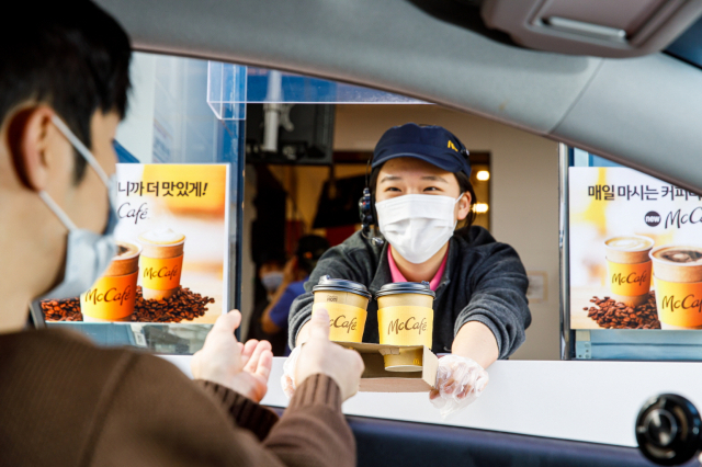 서울의 한 맥도날드 드라이브 스루 매장에서 직원이 고객에게 맥카페 커피를 제공하고 있다. /사진제공=맥도날드