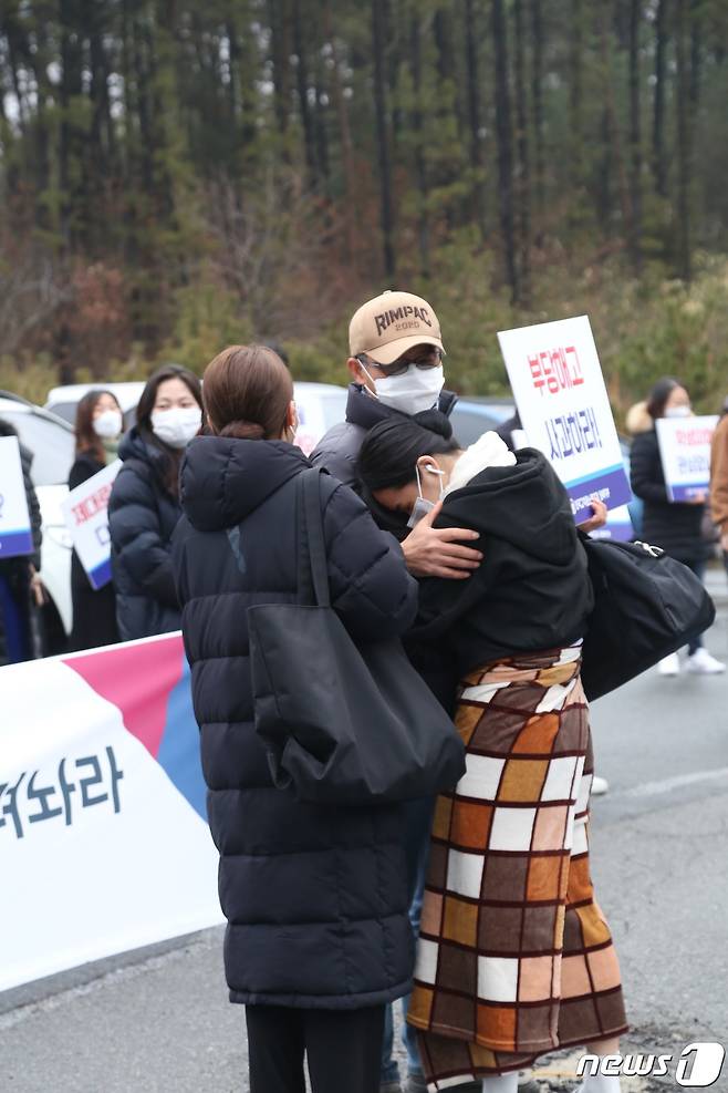 1일 오전 8시께 전북 전주예술중·고등학교 앞에서 해직 교사와 학부모 10여 명이 모여 피켓 시위를 벌였다. 이들은 "부당한 해고를 즉각 철회하라"고 촉구했다. 등교한 학생이 선생님 품에 안겨 눈물을 보이고 있다.2021.2.1/© 뉴스1 이지선기자