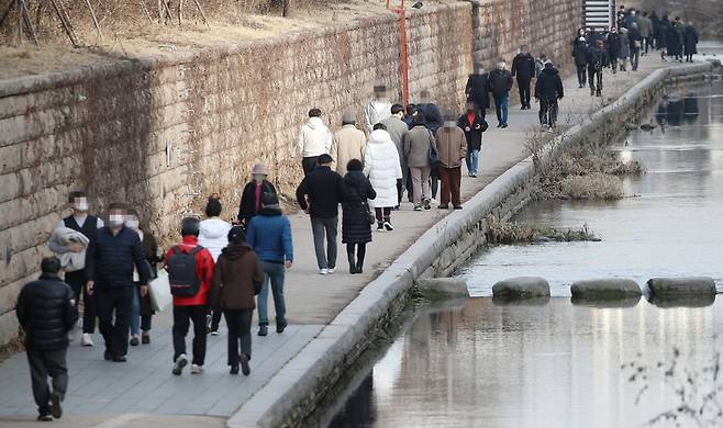 전국 대부분 지역 낮 최고기온이 10도 안팎을 기록한 지난달 31일 오후 서울 종로구 청계천을 찾은 시민들이 산책을 즐기고 있다. 따뜻한 날씨로 사람이 몰린 탓인지 사회적 거리두기가 제대로 지켜지지 않고 있는 모양새다. 같은 날 정부는 현행 거리두기 단계와 방역 기준을 설 연휴가 끝날 때까지 2주간 그대로 연장한다고 밝혔다. [연합]