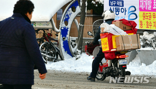 [광주=뉴시스]류형근 기자 =한 우체국 집배원이 한발로 땅을 짚은 채 오토바이를 운전하고 있다. 2018.01.11. hgryu77@newsis.com <사진은 기사와 직접 관련 없습니다.>