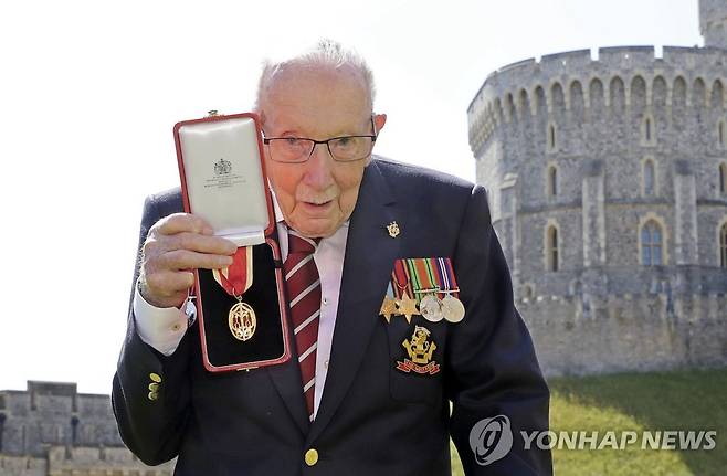 영국의 2차대전 참전용사 톰 무어 경이 지난해 7월 엘리자베스 여왕으로부터 받은 기사 작위 훈장을 들어보이고 있다. [AP=연합뉴스 자료사진]