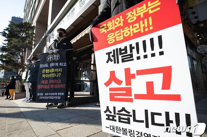 자영업자들이 2일 서울 중구 LW컨벤션에서 열린 '사회적 거리두기 단계 개편을 위한 공개토론회' 토론회장 앞에서 영업시간 연장 등 방역대책 개선을 촉구하는 피켓시위를 하고 있다. 2021.2.2/뉴스1 © News1 유승관 기자