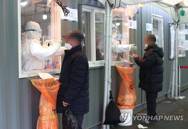 검체 채취하는 의료진 (서울=연합뉴스) 이지은 기자 = 1일 오전 서울역광장에 설치된 임시선별진료소에서 의료진이 검체를 채취하고 있다. 이날 중앙방역대책본부(방대본)에 따르면 0시 기준 코로나19 신규 확진자는 305명이다. 중구 서울역 노숙인 지원시설 관련 확진자는 전날 노숙인 8명이 추가돼 누적 54명(서울 52명)이 됐다. 2021.2.1 jieunlee@yna.co.kr