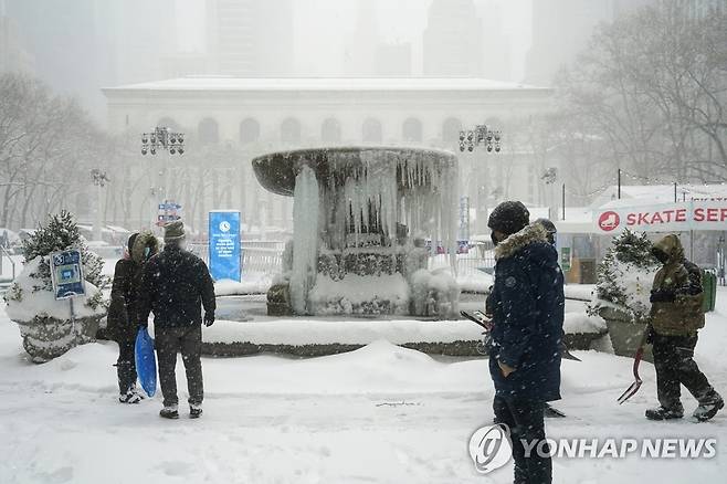 5년만의 폭설로 등교수업·백신접종 중단된 뉴욕 (뉴욕 로이터=연합뉴스) 최근 5년 만에 최대 폭설이 내린 미국 뉴욕 맨해튼에서 1일(현지시간) 시민들이 꽁꽁 얼어붙은 브라이언트 파크의 분수대를 바라보고 있다. 뉴욕·뉴저지주 등 폭설이 심한 미 북동부 여러 주는 비상사태를 선포하고 공립학교 대면 수업을 중단시켰으며 신종 코로나바이러스 감염증(코로나19) 접종소도 일시 폐쇄했다. sungok@yna.co.kr