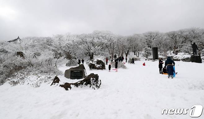 17일 오후 한라산국립공원 1100고지 휴게소에서 관광객들이 겨울 정취를 즐기고 있다. 산간에 내려졌던 대설특보는 이날 나흘만에 해제됐으며 한라산 진달래밭에는 1m가 넘는 적설량을 기록했다.2020.12.17/뉴스1 © News1 오현지 기자