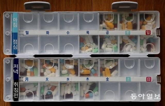 온갖 합병증을 앓는 경란 씨는 10알이 넘는 약을 한 번에 먹는다(위쪽 사진). 하루에 먹는 약이 40알에 이르기 때문에 일주일치 양을 요일별, 시간대별로 먹기 쉽게 분류해 놓는다. 송은석 기자 silverstone@donga.com