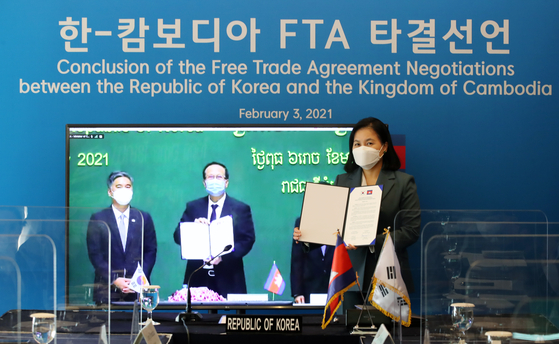 Trade Minister Yoo Myung-hee, far right, poses for a photo with Pan Sorasak, center, minister of commerce of the Royal Government of Cambodia, Wednesday during online FTA negotiations. [YONHAP]