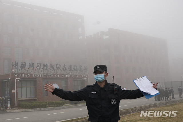 [우한=AP/뉴시스] 3일 중국 후베이성 우한의 바이러스 연구소에서 한 보안요원이 취재진의 접근을 막고 있다. 신종 코로나바이러스 감염증(코로나19)의 기원을 밝혀내기 위해 우한을 방문한 세계보건기구(WHO) 조사단이 이날 코로나19 유출 의혹을 받는 연구소를 방문했다. 2021.02.03