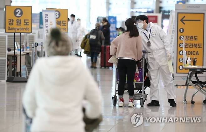 국내에서 영국 변이 바이러스 감염자가 늘고 있는 가운데 지난달 6일 오전 인천국제공항 1터미널 입국장에서 방역 관계자들이 해외입국자들에게 식별 스티커를 부착해주고 있다. 연합뉴스 제공