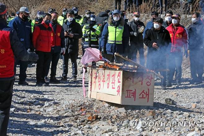 관 불태우는 주민 (포항=연합뉴스) 손대성 기자 = 4일 경북 포항시 수성사격장 앞에서 장기면민이 사격장 폐쇄와 주한미군 아파치헬기 사격훈련 중단을 촉구하는 집회를 하면서 국방부장관과 한미연합사령관 직책을 쓴 나무 관을 태우고 있다. 2021.2.4 sds123@yna.co.kr