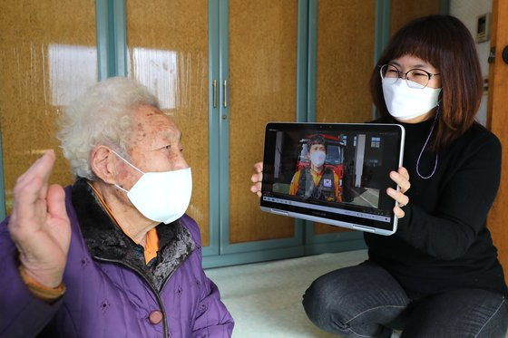 경북 의성군의 한 할머니가 출향한 자녀의 영상 메시지를 보며 손을 흔들고 있다. [사진 의성군]