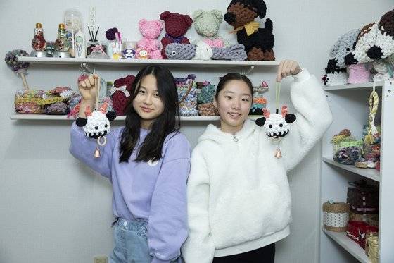 오은교(왼쪽) 학생모델과 김율아 학생기자가 각자 만든 카우벨 양말목 공예품을 들어 보였다. 현관에 걸어놓으면 의미도 있고 보기에도 좋은 인테리어 소품이 된다.