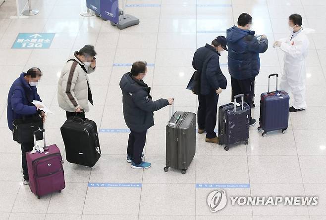 나란히 줄 서서 대기하는 입국자들 설 연휴를 이틀 앞둔 지난 9일 오전 인천국제공항 제1터미널 입국장에서 해외입국자들이 교통편 대기장소로 가기 위해 대기하고 있다. [연합뉴스 자료사진]