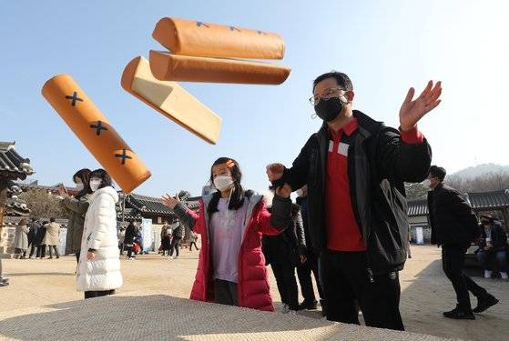 12일 오후 서울 중구 퇴계로 남산골한옥마을에서 열린 남산골 설 축제 '명랑소설'을 찾은 가족이 윷을 던지고 있다. 뉴스1