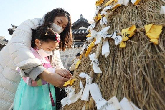 12일 오후 서울 중구 퇴계로 남산골한옥마을에서 열린 남산골 설 축제 '명랑소설'을 찾은 모녀가 소원지를 달고 있다. 뉴스1
