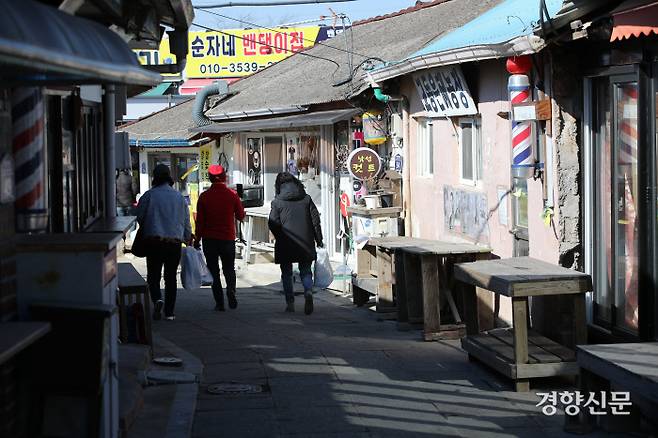 설 연휴를 앞둔 8일 오후 인천 강화군 교동도 대룡시장을 찾은 시민들이 구매한 가래떡을 들고 걷고 있다. / 권도현 기자