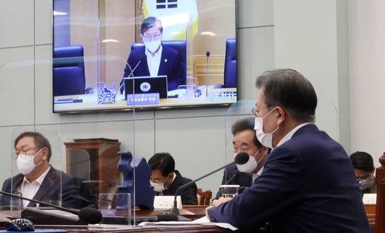 문재인 대통령이 16일 오후 청와대에서 화상회의 형식으로 열린 국토교통부 2021년 업무보고에서 변창흠 국토교통부장관의 보고를 받고 있다. ［연합뉴스］