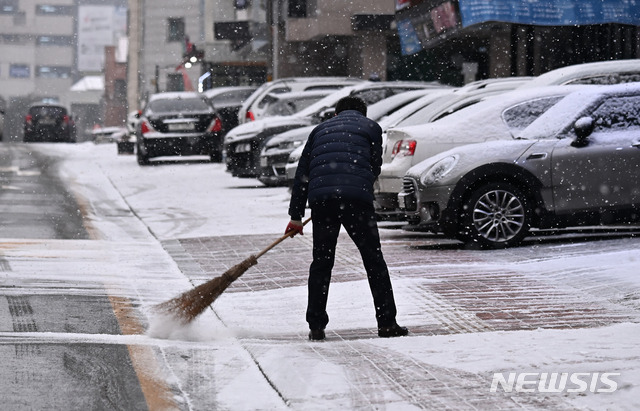 [수원=뉴시스] 김종택기자 = 눈이 내린 18일 오전 경기도 수원시 영통구 이의동 주택가에서 한 시민이 눈을 치우고 있다. 2021.01.18.jtk@newsis.com