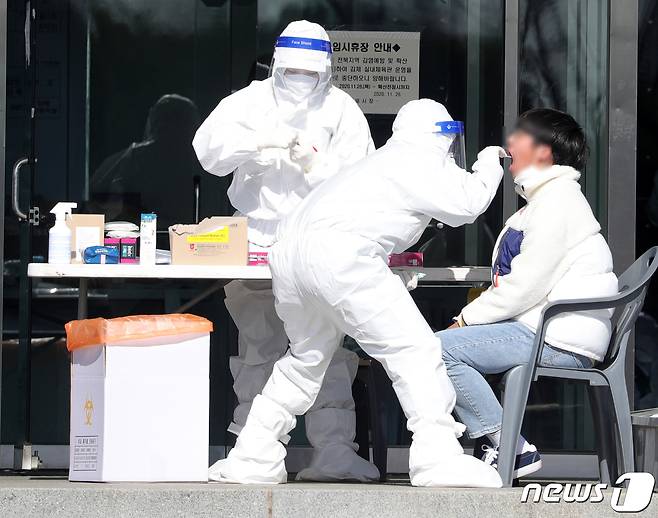 지난 달  27일 김제시 실내체육관에 마련된 임시 선별진료소를 찾은 시민들이 검사를 받고 있다. 2021.1.27/뉴스1 © News1 유경석 기자