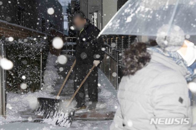 [광주=뉴시스] 김혜인 기자 = 광주와 전남 일부지역에 대설특보가 내려진 7일 오전 광주 동구 금남로 한 건물 관계자가 제설 작업을 하고있다. 2021.01.07.hyein0342@newsis.com