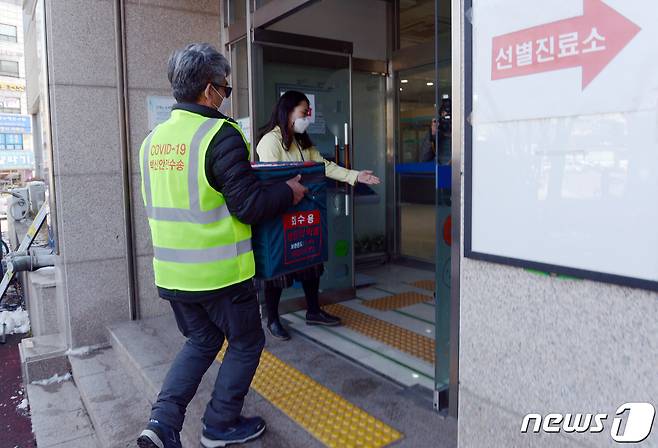 19일 오후 광주 북구보건소 정문에서 경기도 이천 물류센터에서 배송된 아스트라제네카 모형 백신이 안으로 옮겨지고 있다. 2021.2.19/뉴스1 © News1 허단비 기자