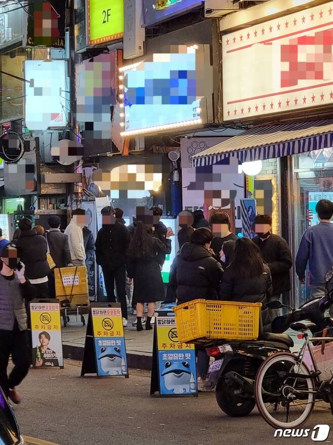 20일 오후 9시께 서울 강북구 수유역 먹자골목 한 술집 앞에서 사람들이 담배를 피우고 있다. © 뉴스1 이상학 기자