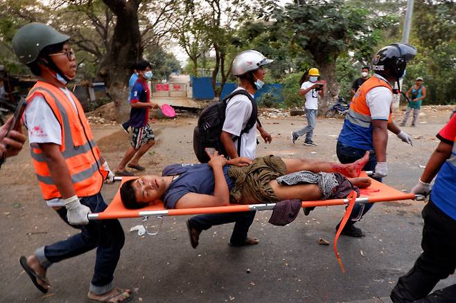 미얀마 만달레이에서 20일(현지시간) 군사 쿠데타 반대 시위를 벌인 한 시민이 부상을 입고 이송되고 있다. 로이터연합뉴스