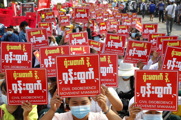 19일(현지시간) 미얀마 제2의 도시 만달레이에서 시위대가 '시민 불복종 운동'을 촉구하는 팻말을 들고 쿠데타 규탄 시위를 벌이고 있다. 만달레이 AP=연합뉴스