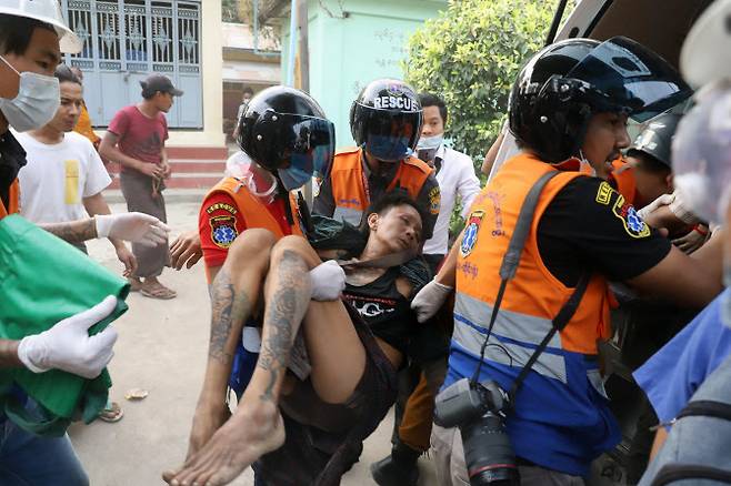 20일 만달레이에서 벌어진 반 쿠데타 시위에서 한 남성이 구조대에 의해 옮겨지고 있다(사진=AFP)