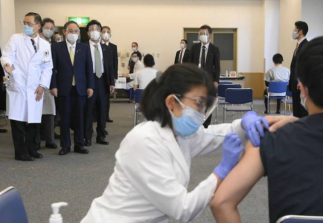 스가 요시히데 일본 총리(사진 위 왼쪽 두 번째)가 18일 일본 도쿄 의료 센터를 찾아 코로나19 백신 접종을 지켜보고 있다. (사진=AFPBBNews)