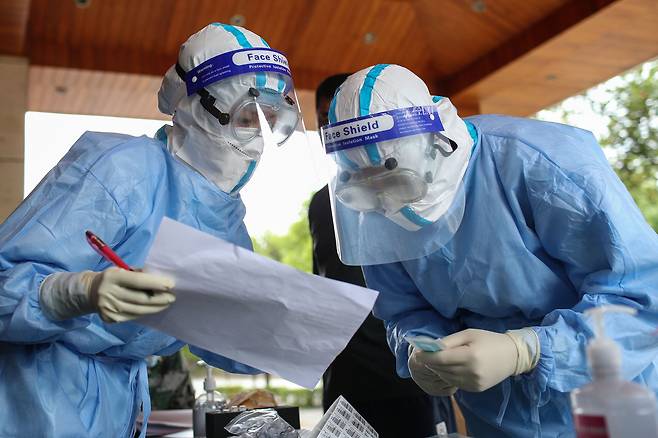 지난해 9월 중국 의료진들이 윈난성 루이리 주민들을 대상으로 한 코로나19 바이러스 검사에 앞서 정보를 확인하고 있다. AFP=연합뉴스