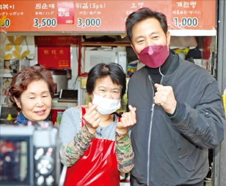 오세훈 국민의힘 서울시장 예비후보(오른쪽)가 21일 서울 대현동 이화여대 인근 상가에서 상인들과 사진을 찍고 있다.   국회사진기자단